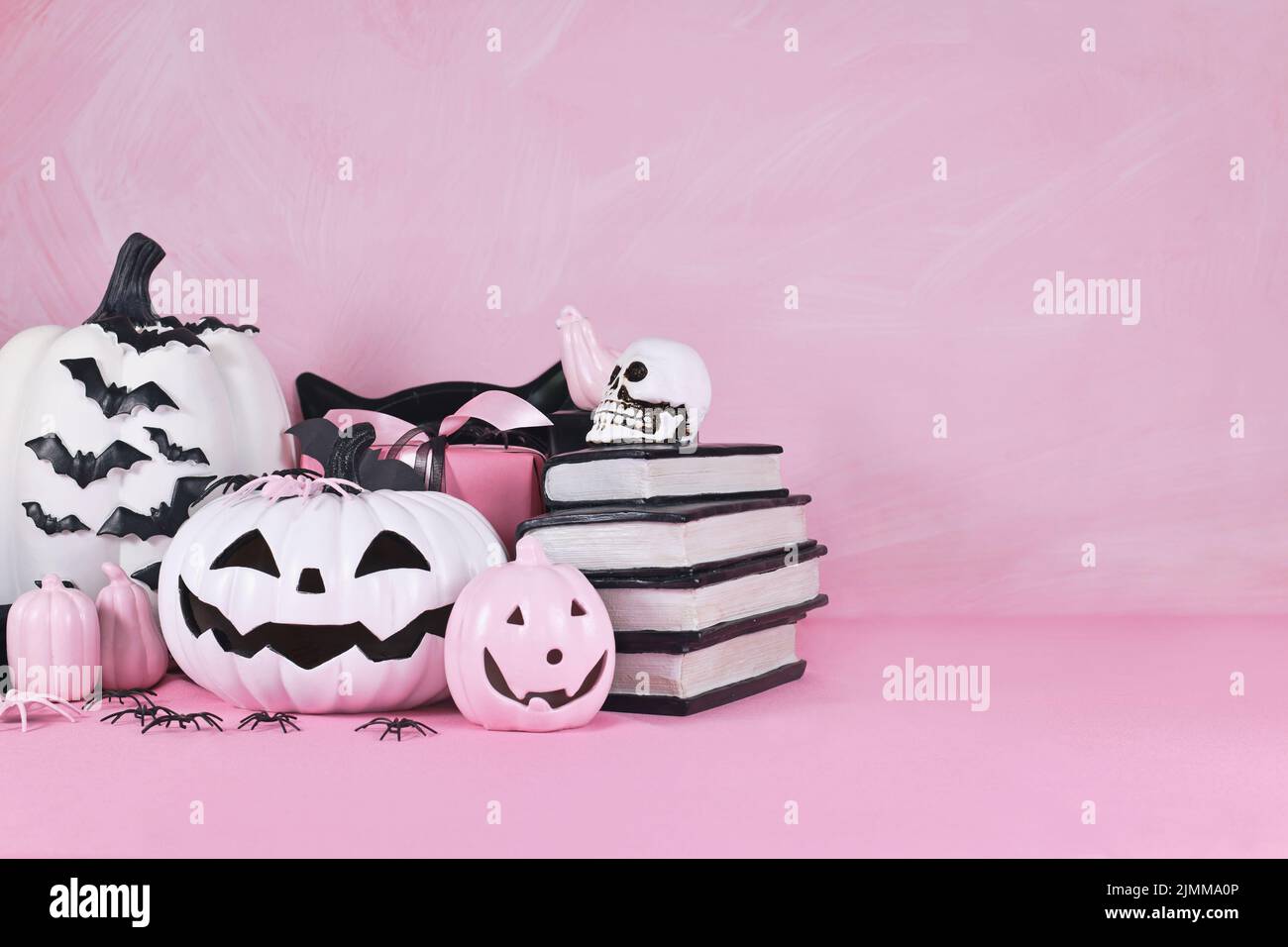Pink Halloween decor with black and white pumpkins, spell books and