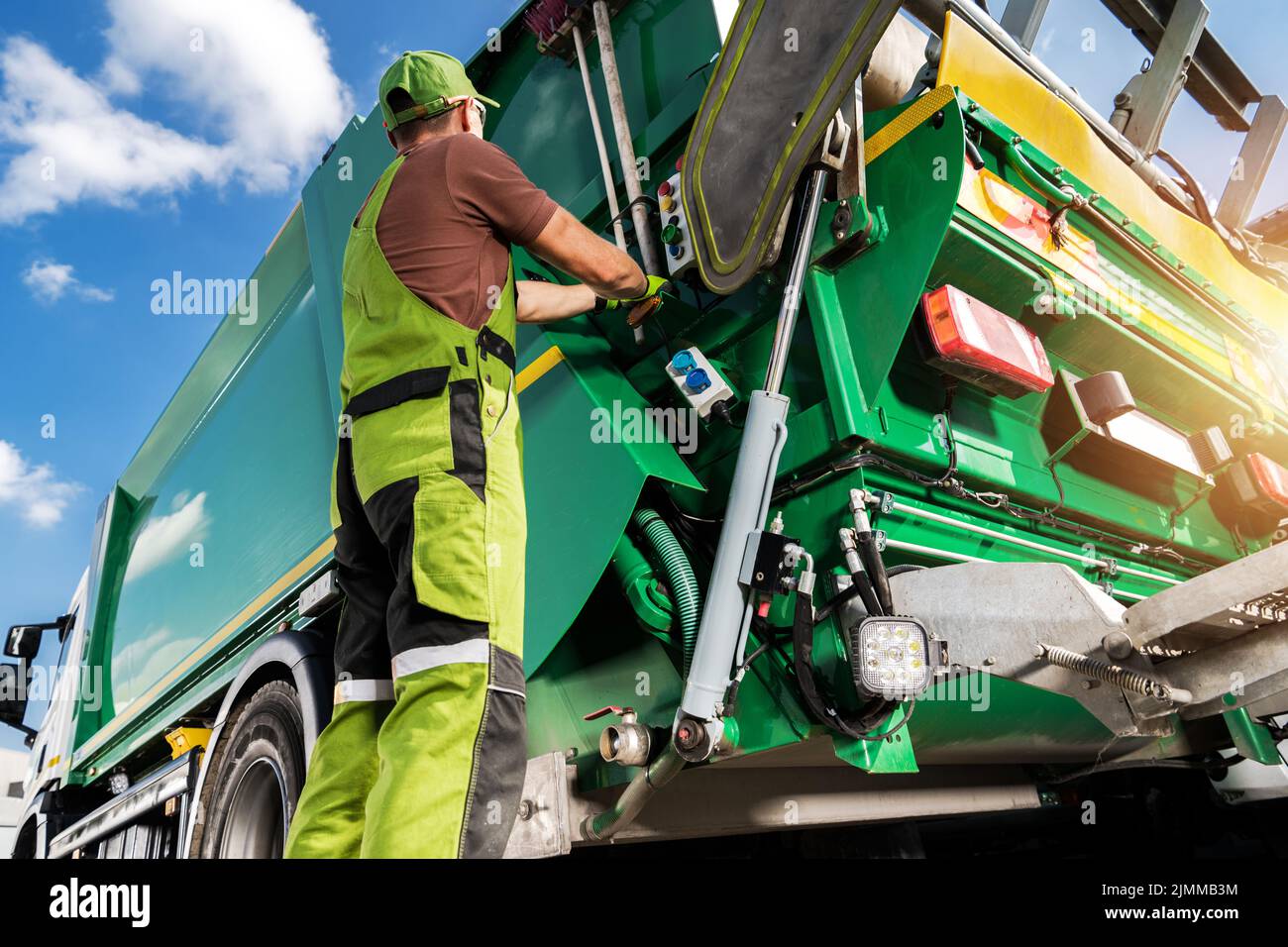 Modern Garbage Truck and Caucasian Waste Collector Worker. Waste Sorting and Management Theme. Stock Photo