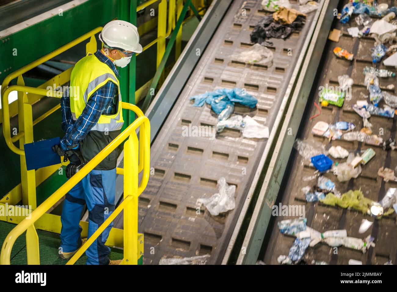 Waste Sorting Facility Management Control. Trash Conveyors Operator Performing Daily Check. Stock Photo
