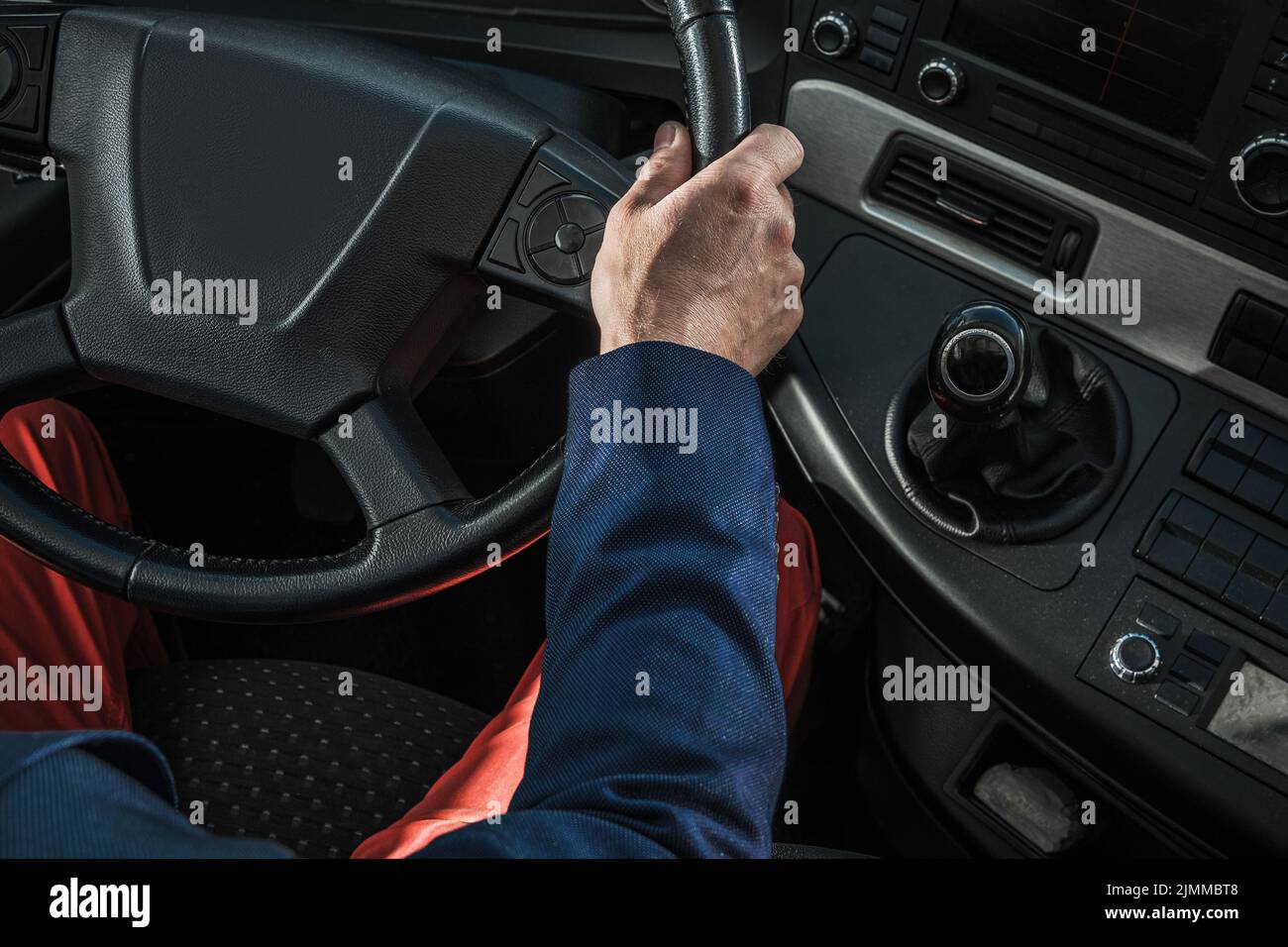 Aerial View of Driver’s Sear and Control Panel in a Heavy Duty Semi Truck. Professional Trucker Holding the Steering Wheel Ready to Start the Route. T Stock Photo