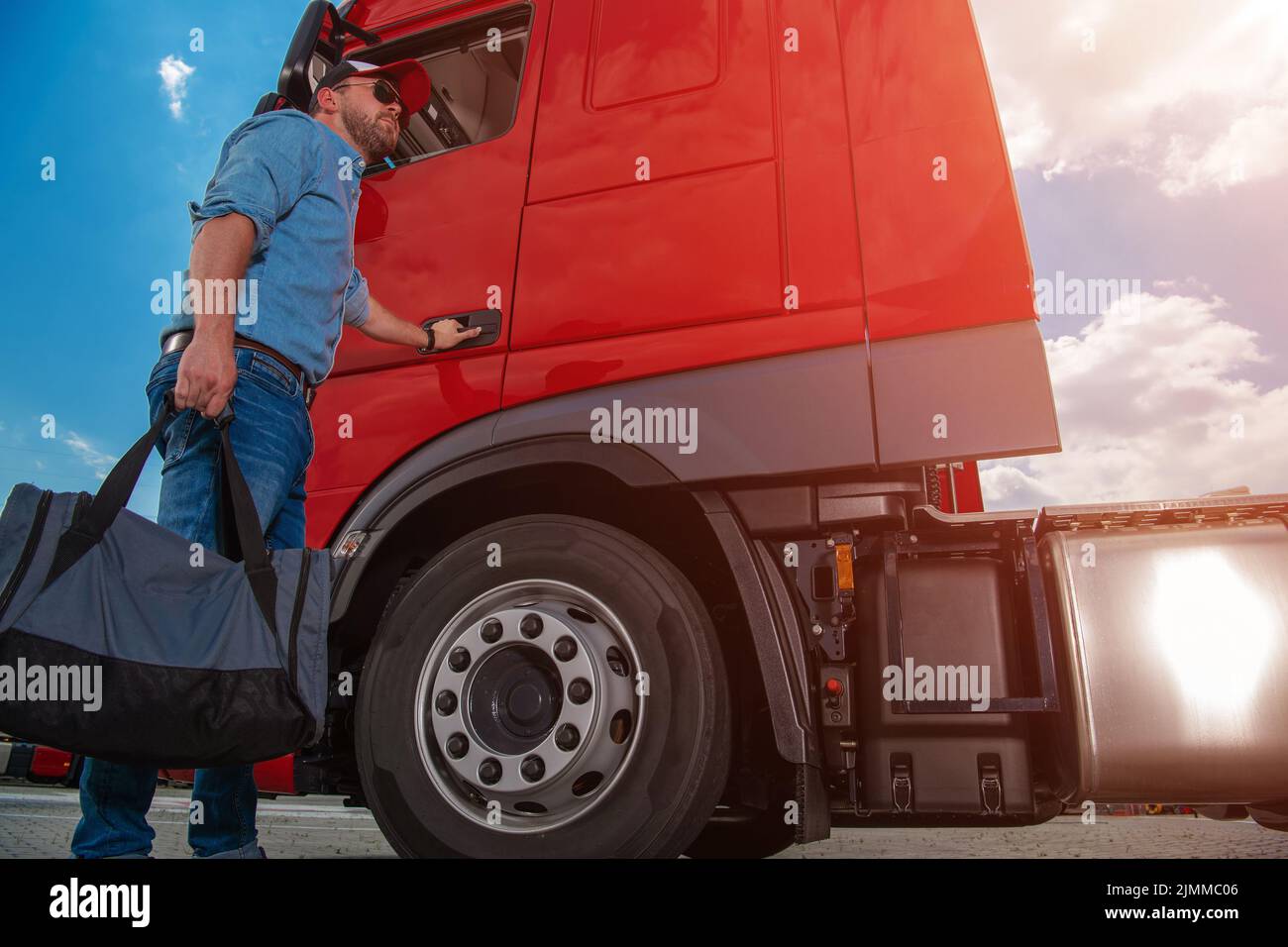 Caucasian Lorry Driver With a Bag in His Hand Opening the Cab Door to