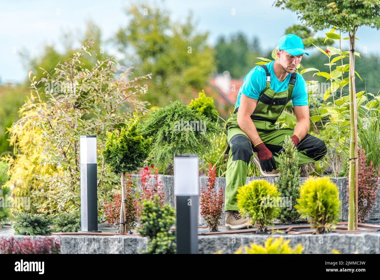 Caucasian Middle Aged Male Gardener Taking a Moment of Rest During Landscaping Large Island Bed in His Client’s Backyard Garden. Professional Landscap Stock Photo
