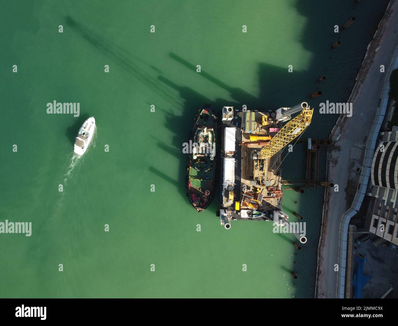 Floating crane dredging barges working on the construction of a marina