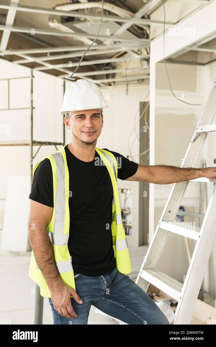 Worker wearing hard hat nad safety vest on a construction site Stock Photo