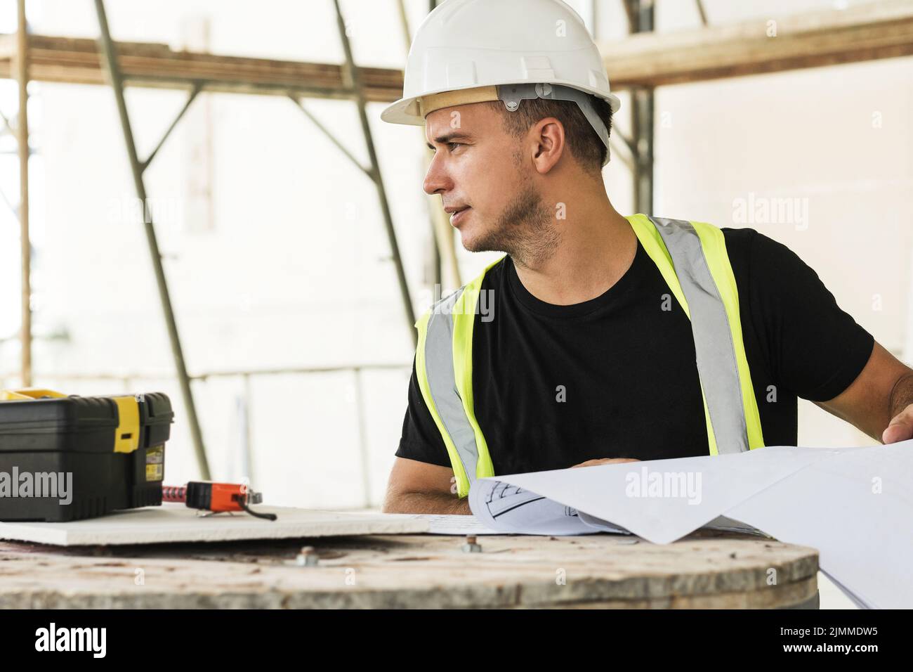 Worker is checking blueprints during his work on a construction site Stock Photo