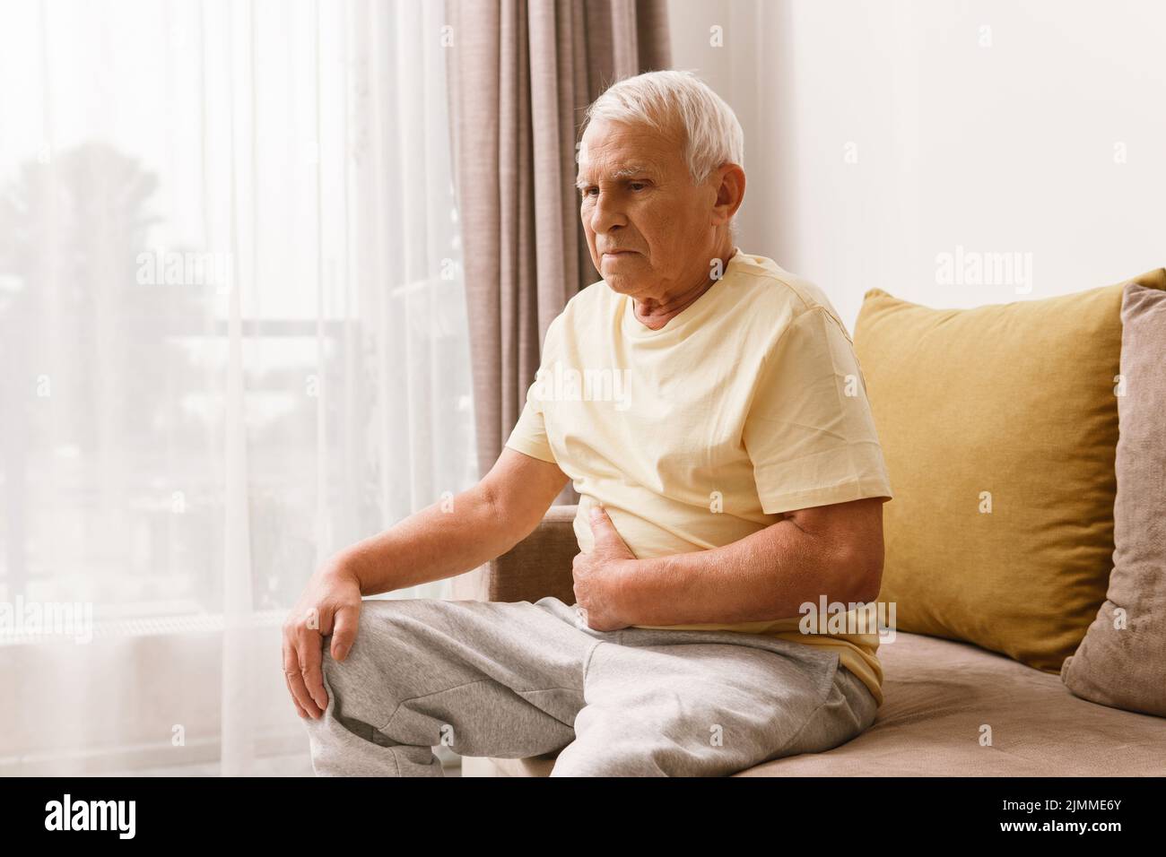 Senior man is suffering from problems with a digestion Stock Photo