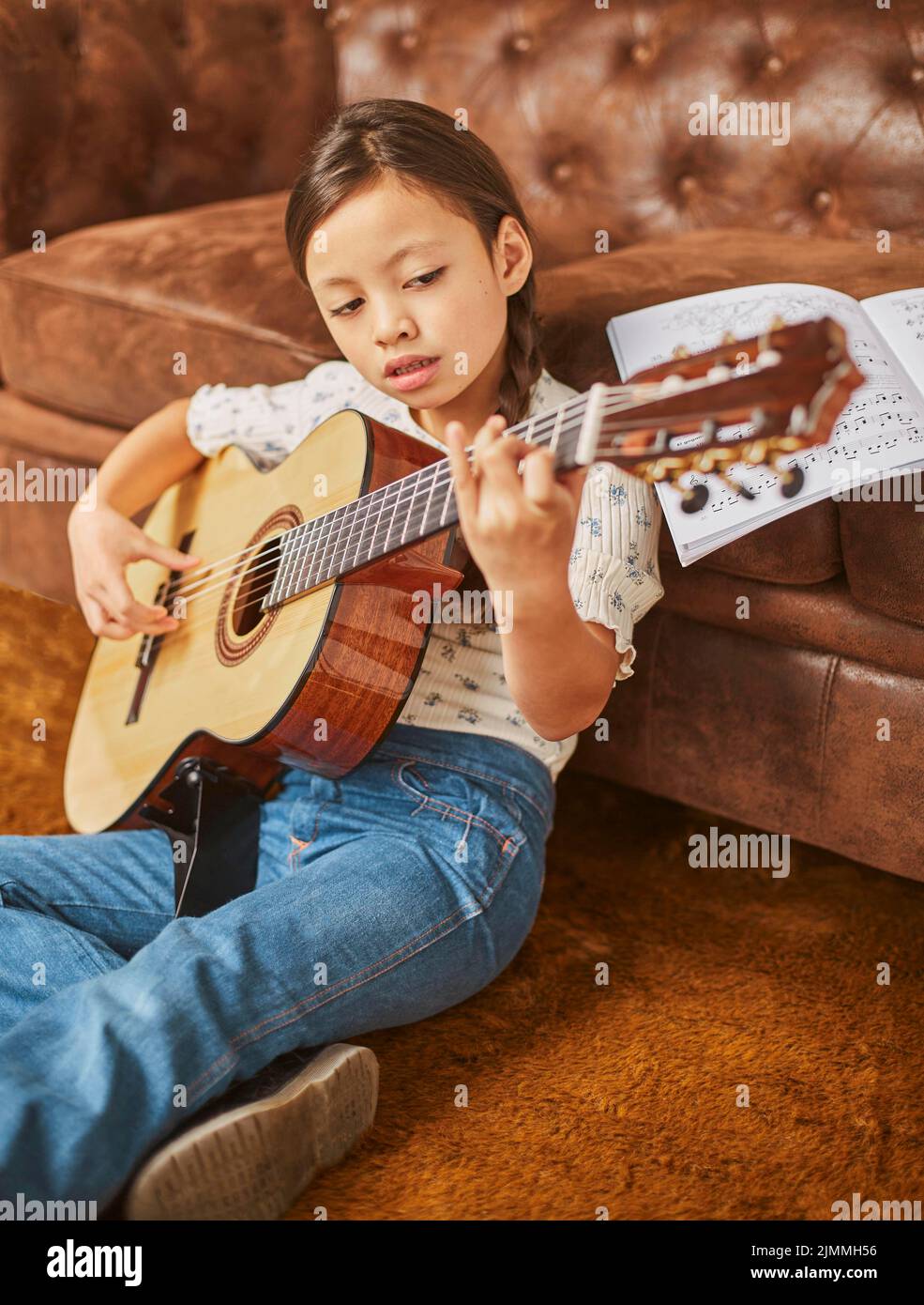 Girl learning how play guitar home Stock Photo