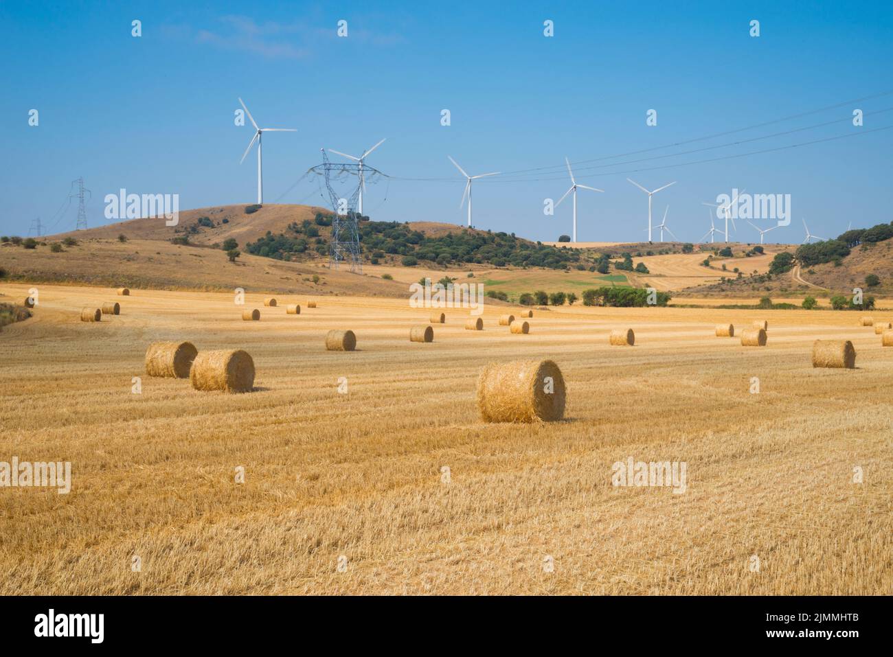 Straw bales and wind farm. La Bureba, Burgos province, Castilla Leon, Spain. Stock Photo