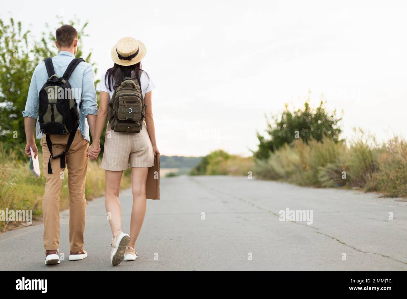 Back view young couple walking down road Stock Photo