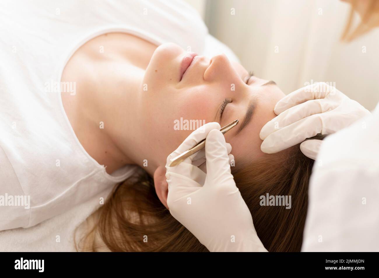 Woman getting eyebrow treatment Stock Photo