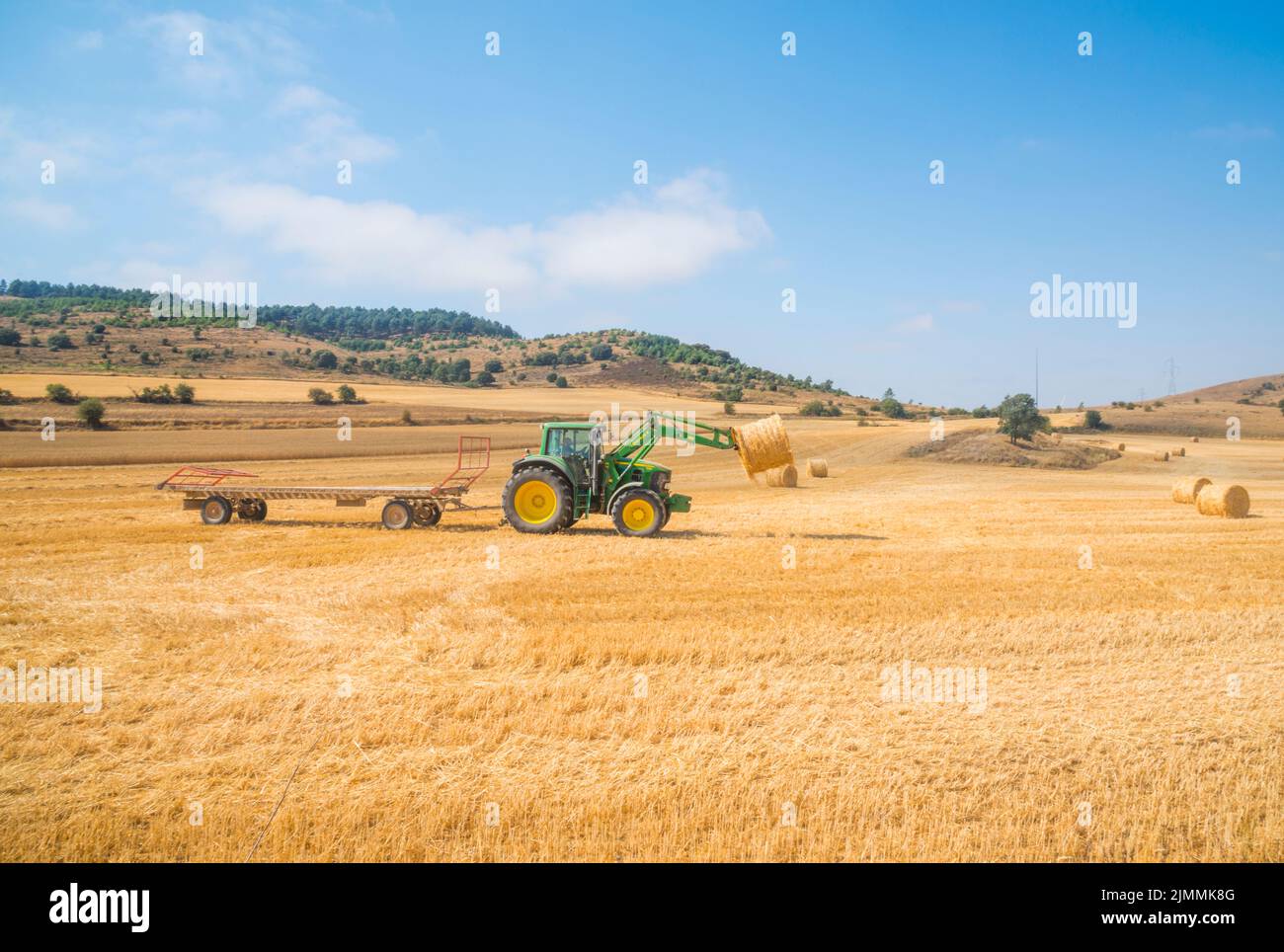 Tractor working with straw bales. La Bureba, Burgos province, Castilla Leon, Spain. Stock Photo