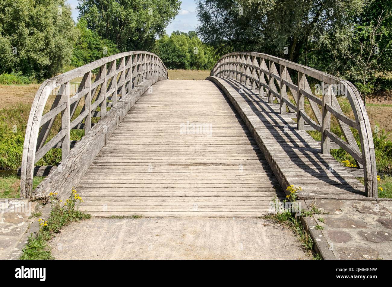Munster, Germany, July 28, 2022: old and weathered wooden bridge across the river Ems for bicyclists and pedestrians Stock Photo