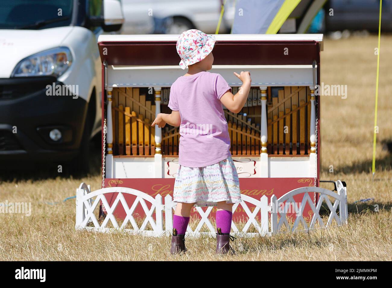 Woodchurch, Kent, UK. 07 August, 2022. On a hot and sunny day in the Kent countryside thousands of people arrive at one of the largest steam rally events in the south east. A young girl enjoys a tune from an pipe organ. Photo Credit: Paul Lawrenson/Alamy Live News Stock Photo