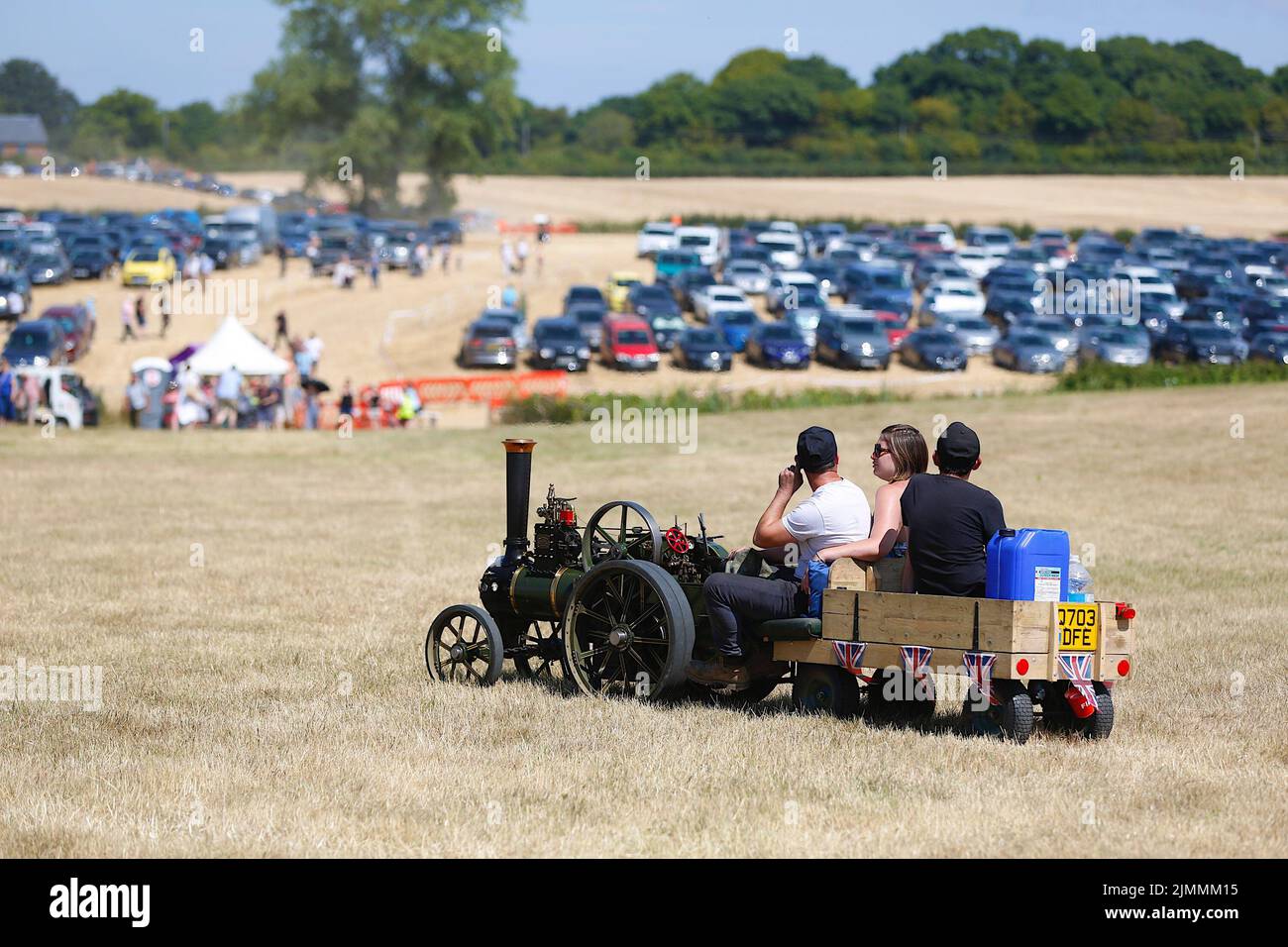 Woodchurch, Kent, UK. 07 August, 2022. On a hot and sunny day in the Kent countryside thousands of people arrive at one of the largest steam rally events in the south east. A mini steam engine looks on at the arrival of more visitors. Photo Credit: Paul Lawrenson/Alamy Live News Stock Photo