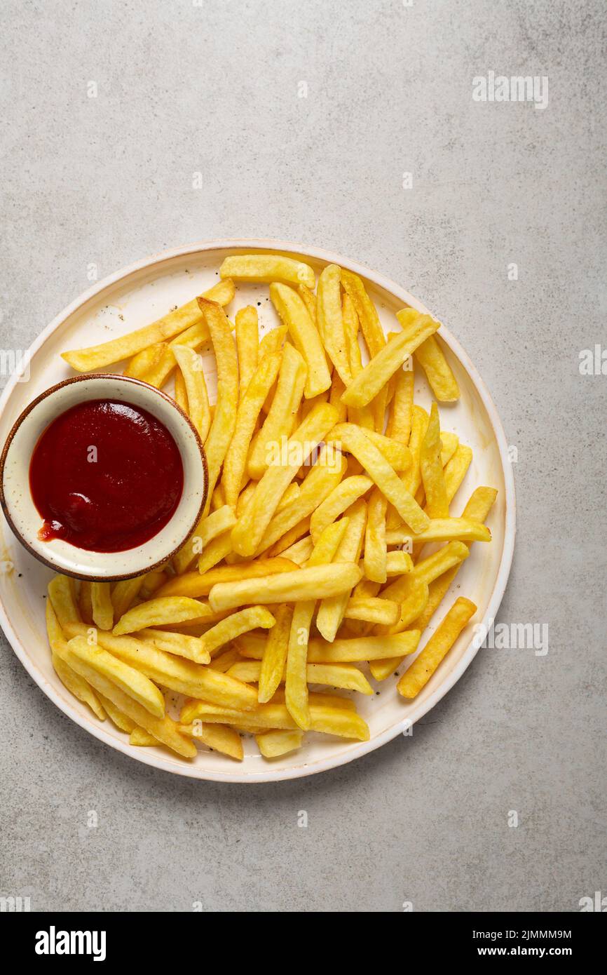 Top view of golden potato chips french fries and ketchup on platter fast food Stock Photo