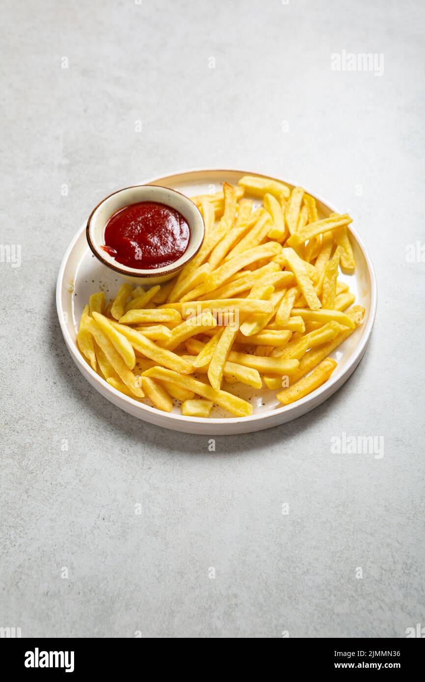 Golden potato chips french fries and ketchup on platter fast food Stock Photo