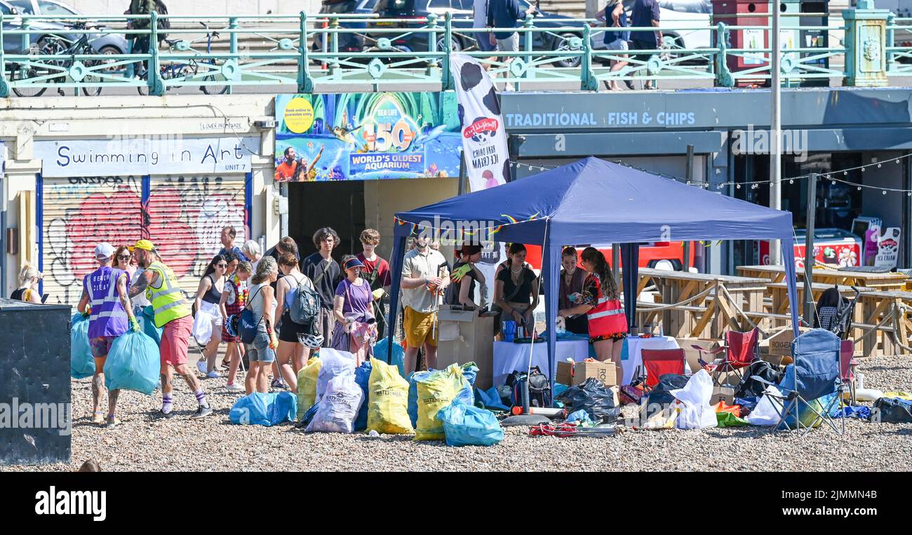 Brighton UK 7th August 2022 - A small army of volunteers help clean up brighton beach and seafront on a hot sunny day as thousands of visitors are in the city for the Pride Festival Weekend celebrations . More hot weather is forecast for parts of the UK over the next week with temperatures xpected to go above 30 degrees again : Credit Simon Dack / Alamy Live News Stock Photo