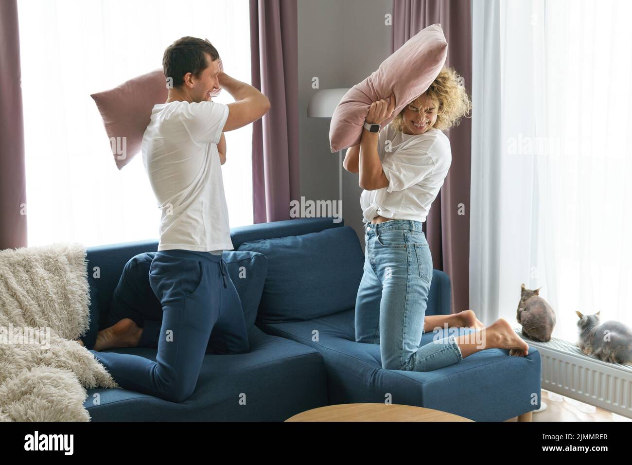 Happy couple during pillow fight in their apartment Stock Photo