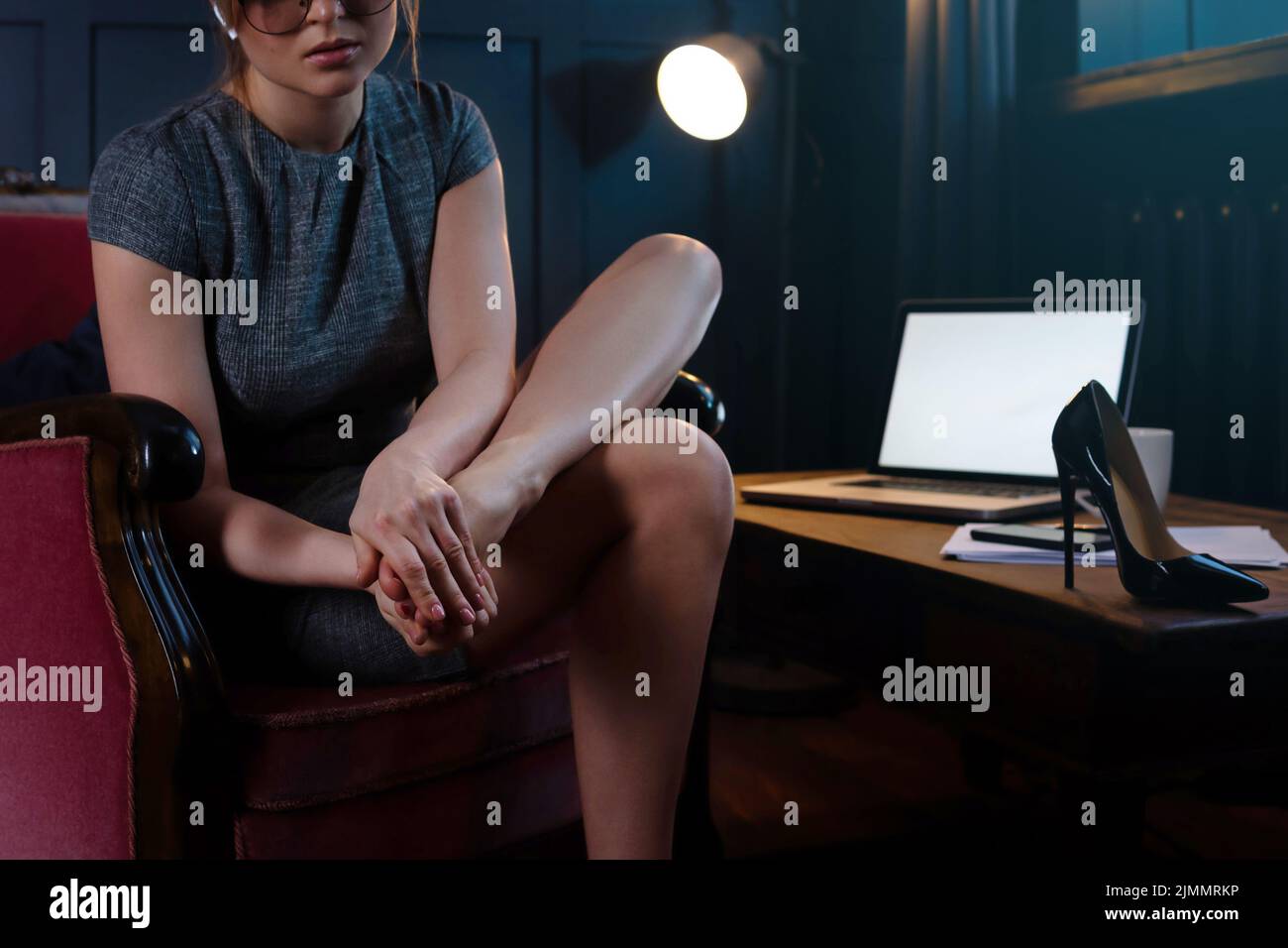 Business woman with aching feet after long working day of wearing high heels Stock Photo