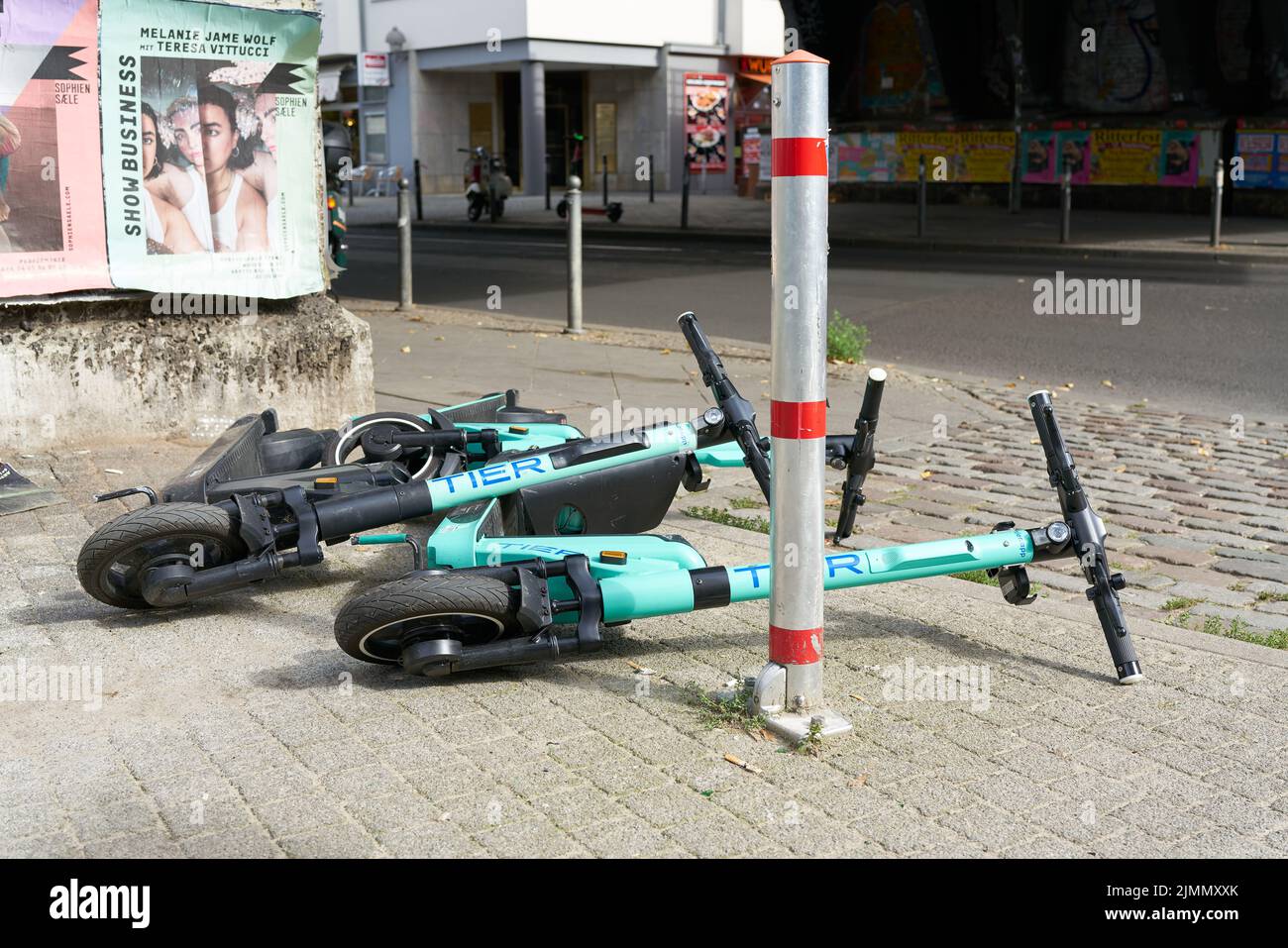 E-scooters of the rental company TIER Mobility lying on a sidewalk in downtown Berlin Stock Photo