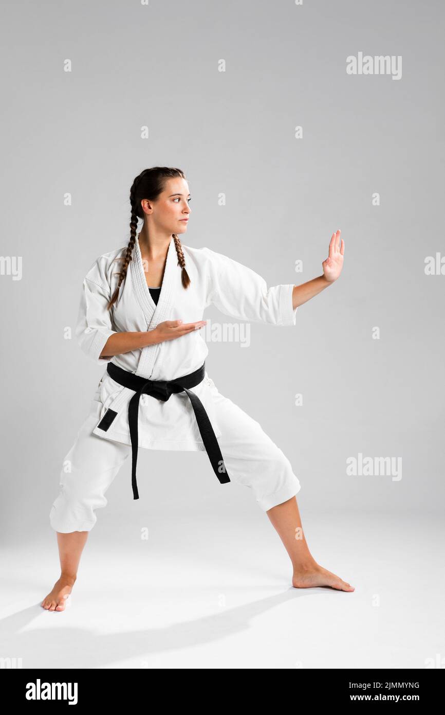 Full length shot woman with black belt kimono practicing karate Stock Photo