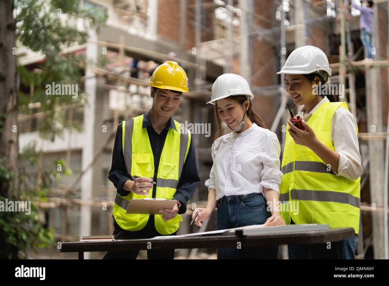 Young asian inspectors and architects discuss with head engineer about construction project. Stock Photo
