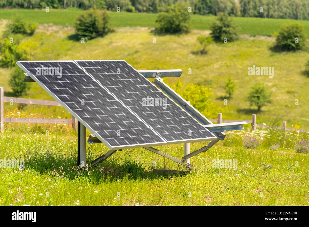 Two solar panels with photovoltaic cells mounted in a frame in a farm