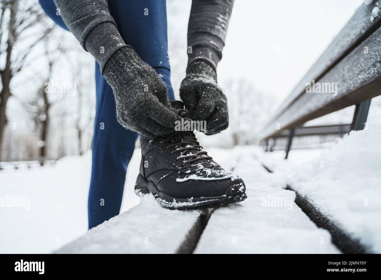 Jogger man lacing his shoes during his winter workout Stock Photo