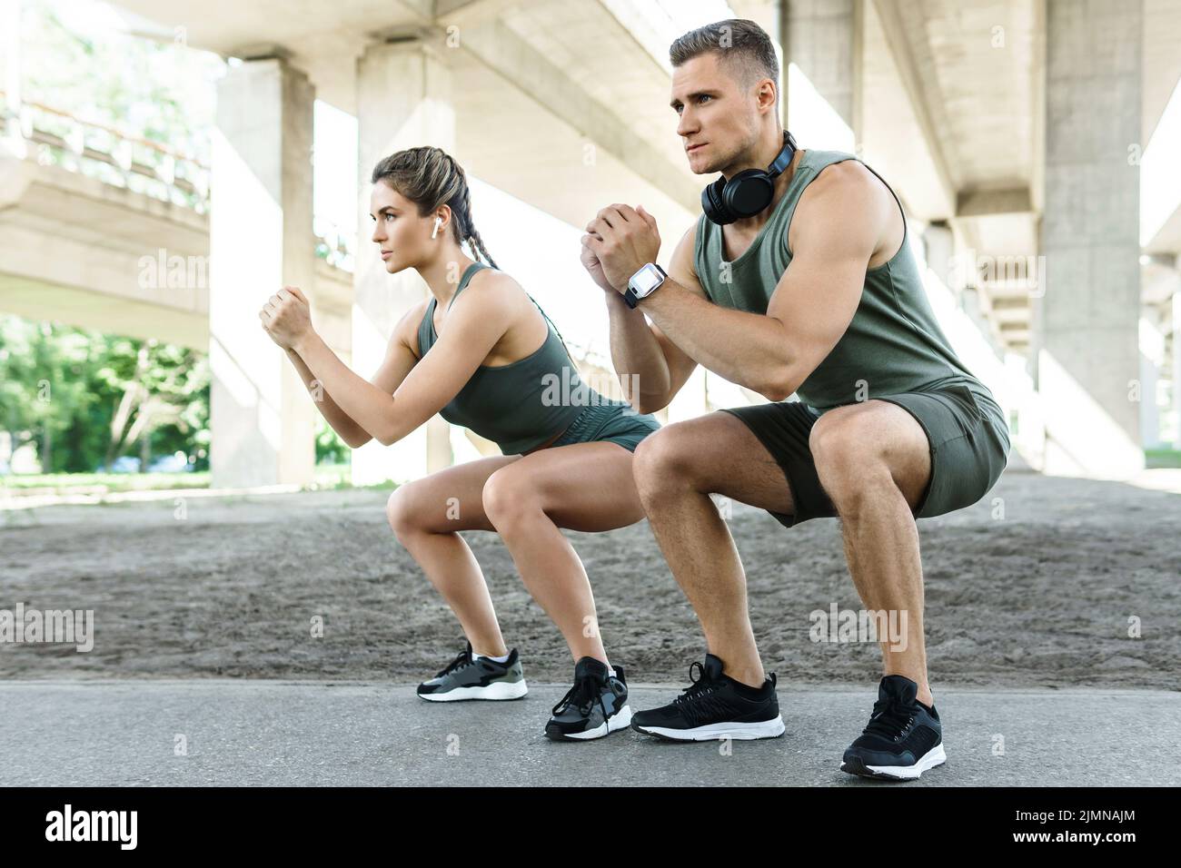 Athletic couple doing squats during street workout Stock Photo