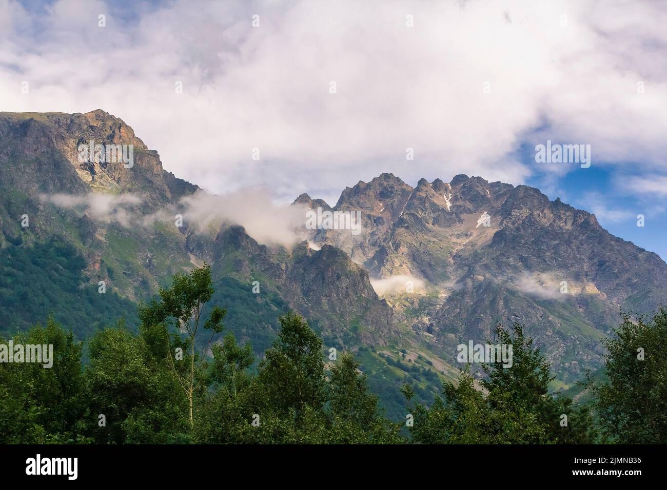 View of huge mountains with waterfalls and beautiful clouds in North Ossetia Stock Photo