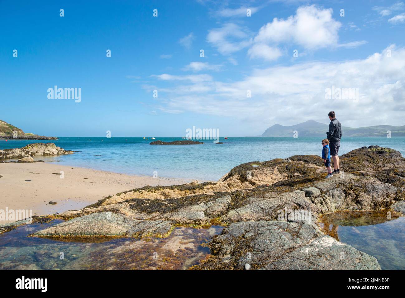A father and son looking out to sea from Porthdinllaen near Morfa Nefyn, Lleyn Peninsula, North Wales. Stock Photo