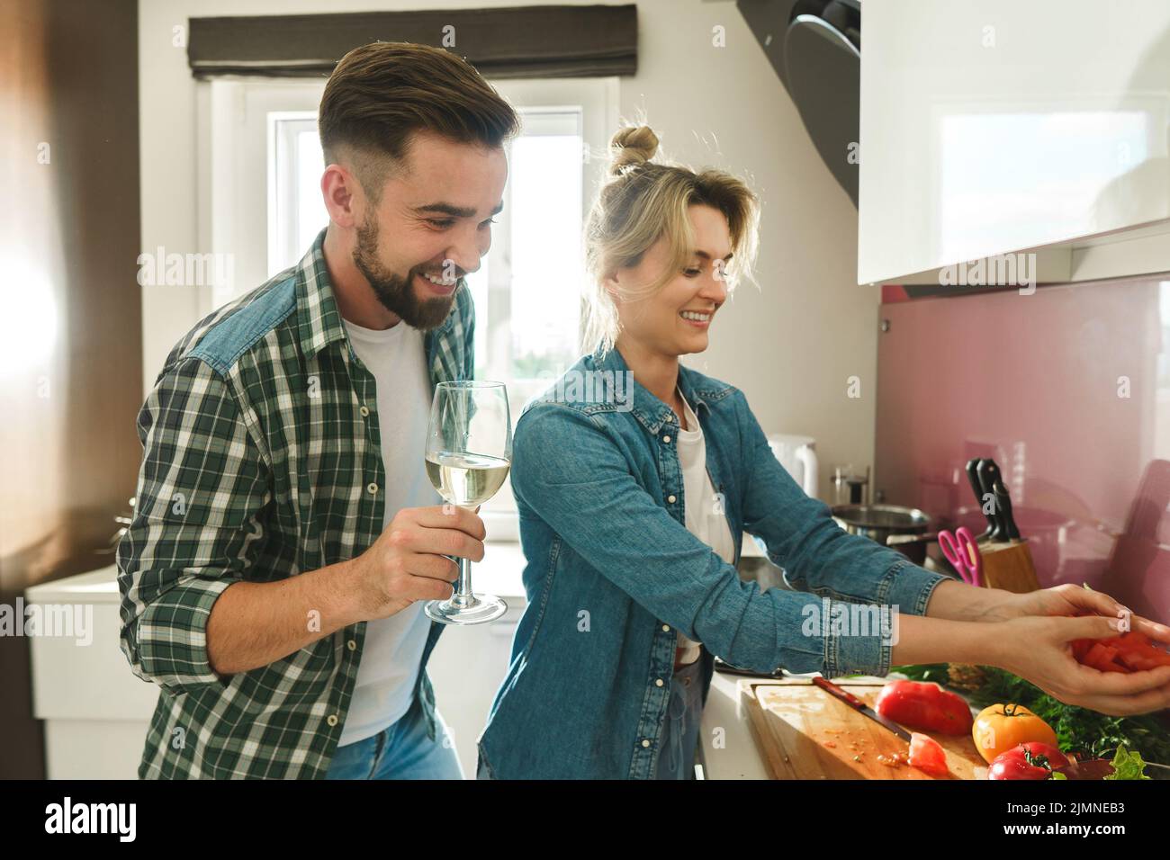 Happy couple cooking launch and drinking wine together in the kitchen