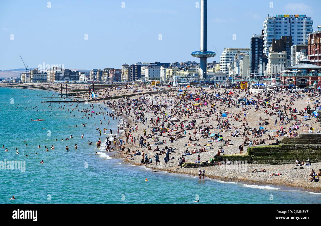 Brighton UK 7th August 2022 - Sunbathers enjoy the hot sunny weather on Brighton beach as thousands of visitors are in the city for the Pride Festival Weekend celebrations . More hot weather is forecast for parts of the UK over the next week with temperatures expected to go above 30 degrees again : Credit Simon Dack / Alamy Live News Stock Photo