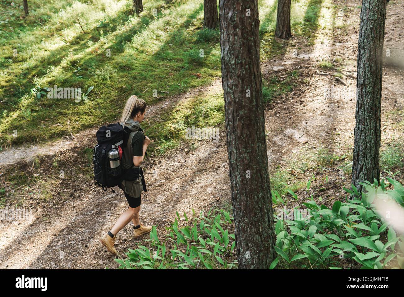 Female hiker with big backpack in green forest Stock Photo - Alamy
