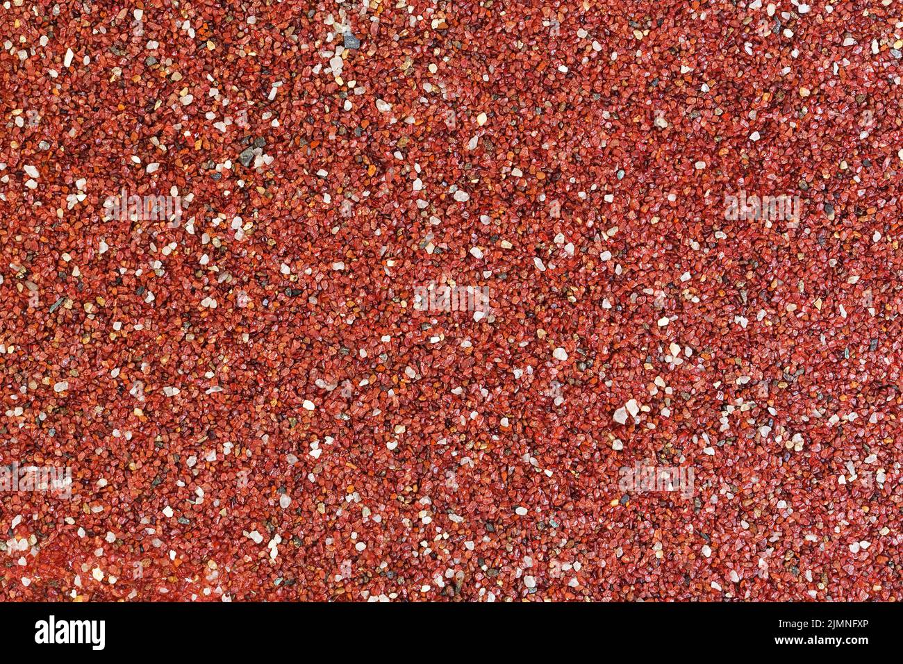 Red stones background. Textured surface covered with small stones. Stock Photo