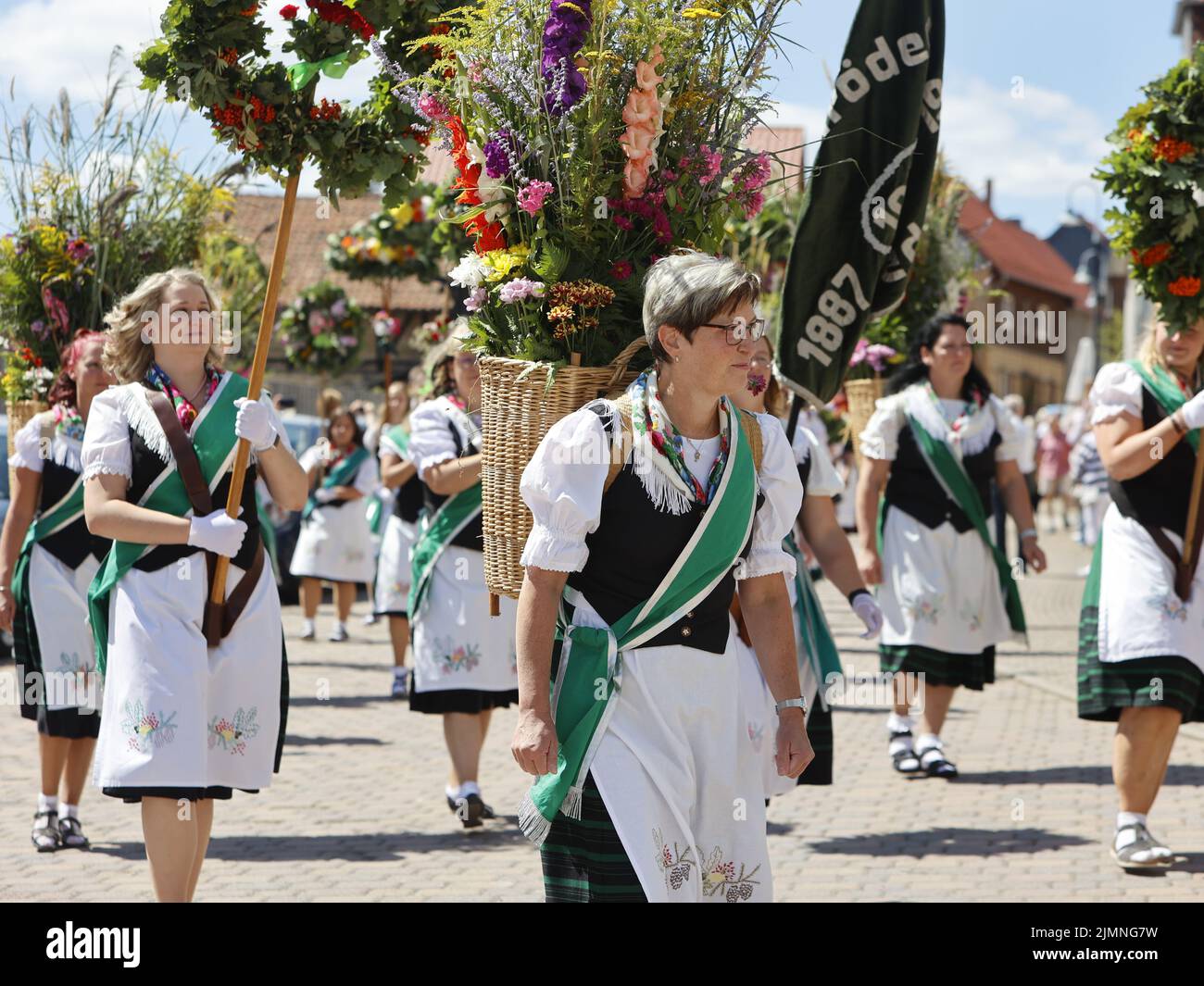 07 August 2022, Saxony-Anhalt, Hüttenrode: Participants of the 'Grasedanz' pageant parade through the village. The Grasekönigin has been elected in Hüttenrode every year since 1885. The custom festival, which focuses on women, is celebrated annually on the first weekend in August. Photo: Matthias Bein/dpa Stock Photo