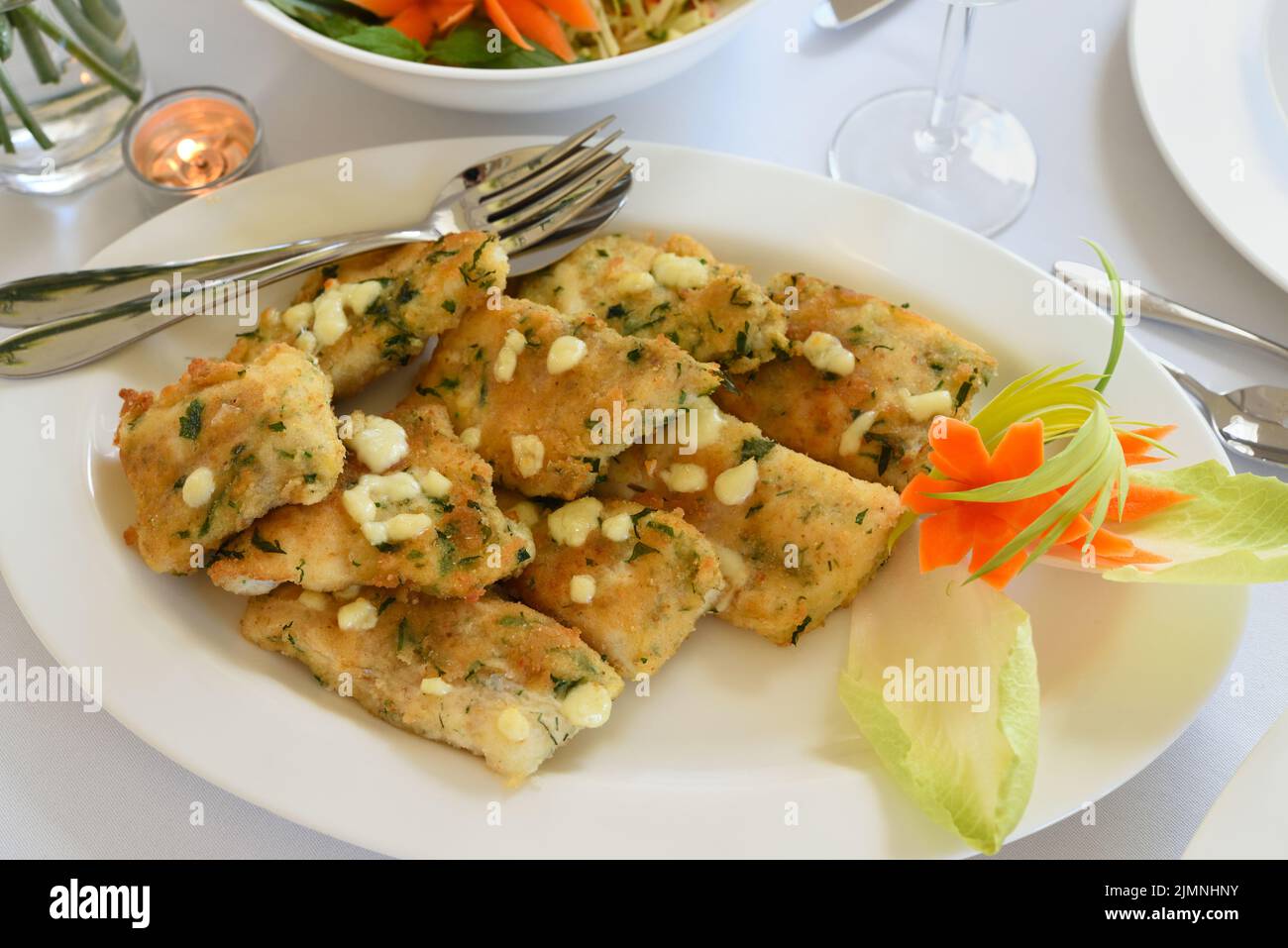 Fried cod fillets in herb crumble on a plate Stock Photo