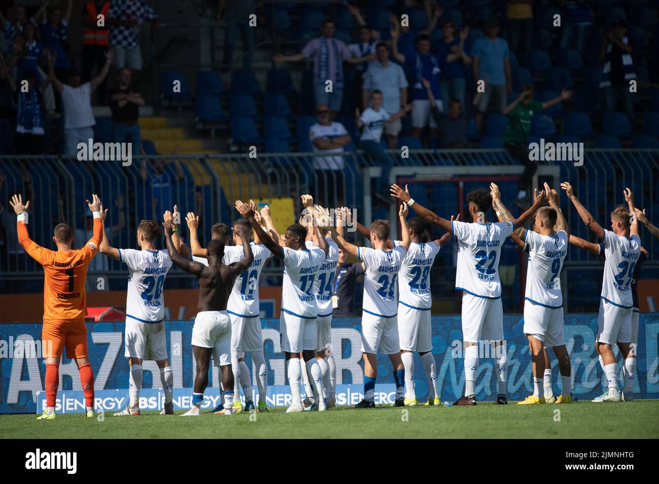 07 August 2022, Lower Saxony, Brunswick: Soccer: 2nd Bundesliga, Eintracht Braunschweig - Darmstadt 98, Matchday 3, Eintracht Stadium. Darmstadt's players cheer with arms raised with the fans after the game. Photo: Swen Pförtner/dpa - IMPORTANT NOTE: In accordance with the requirements of the DFL Deutsche Fußball Liga and the DFB Deutscher Fußball-Bund, it is prohibited to use or have used photographs taken in the stadium and/or of the match in the form of sequence pictures and/or video-like photo series. Stock Photo
