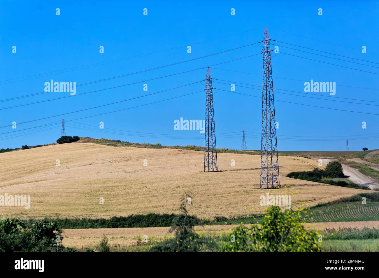Power lines and pylon electricity pols along with crop fields in the rural area. Tekirdag, Turkey. Stock Photo