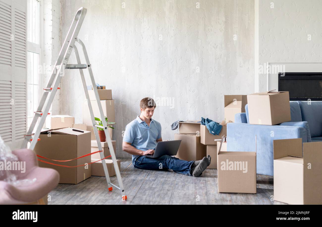 Man home with boxes ladder getting ready move out Stock Photo