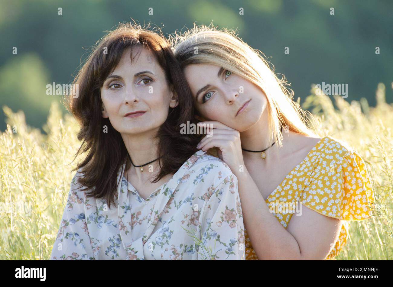 Mature mother with her middle age daughter spending time together outdoors summer time Stock Photo