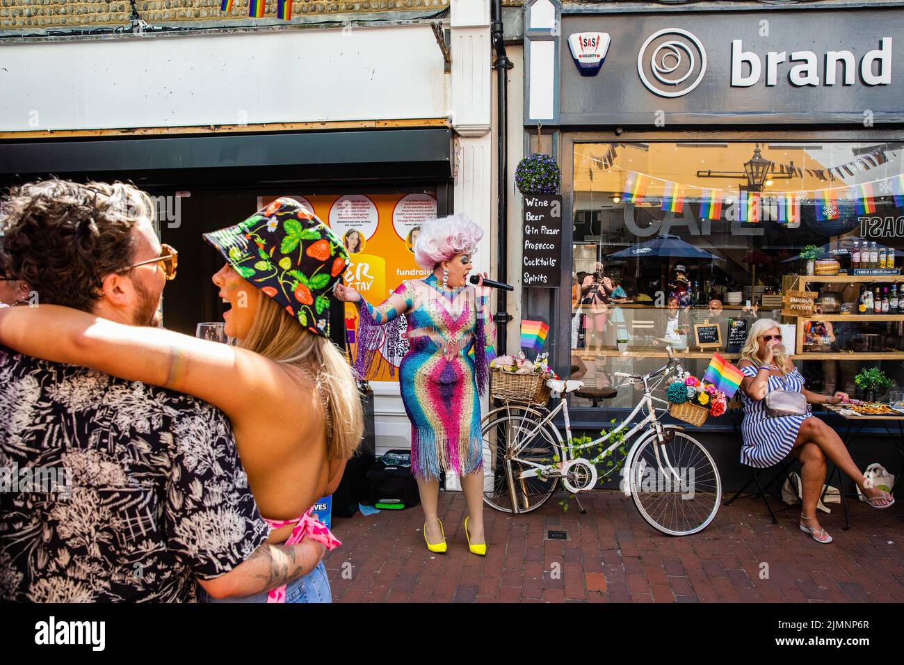 Brighton, UK. 6th August, 2022. Drag cabaret singer Lovinia Belle entertains revellers outside an independent cafe on the occasion of the 30th anniversary Brighton & Hove Pride LGBTQ+ Community Parade. Brighton & Hove Pride is intended to celebrate, and promote respect for, diversity and inclusion within the local community as well as to support local charities and causes through fundraising. Credit: Mark Kerrison/Alamy Live News Stock Photo