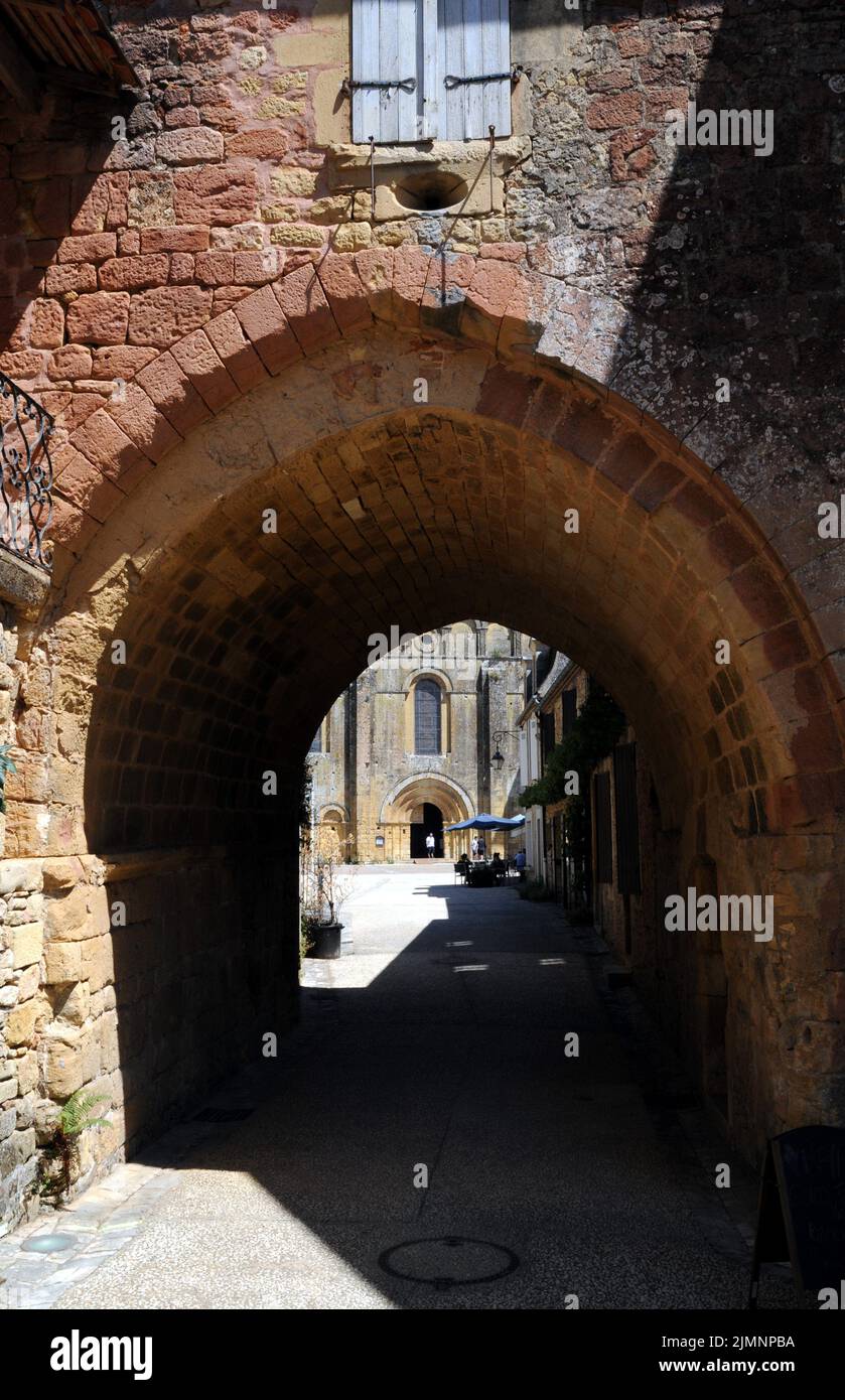 An archway in the village of Cadouin, Perigord Noir, leads from a narrow street through to the large market square and the beautiful abbey church. Stock Photo