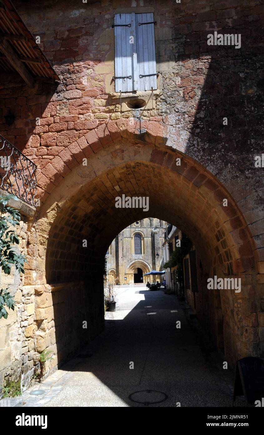 An archway in the village of Cadouin, Perigord Noir, leads from a narrow street through to the large market square and the beautiful abbey church. Stock Photo