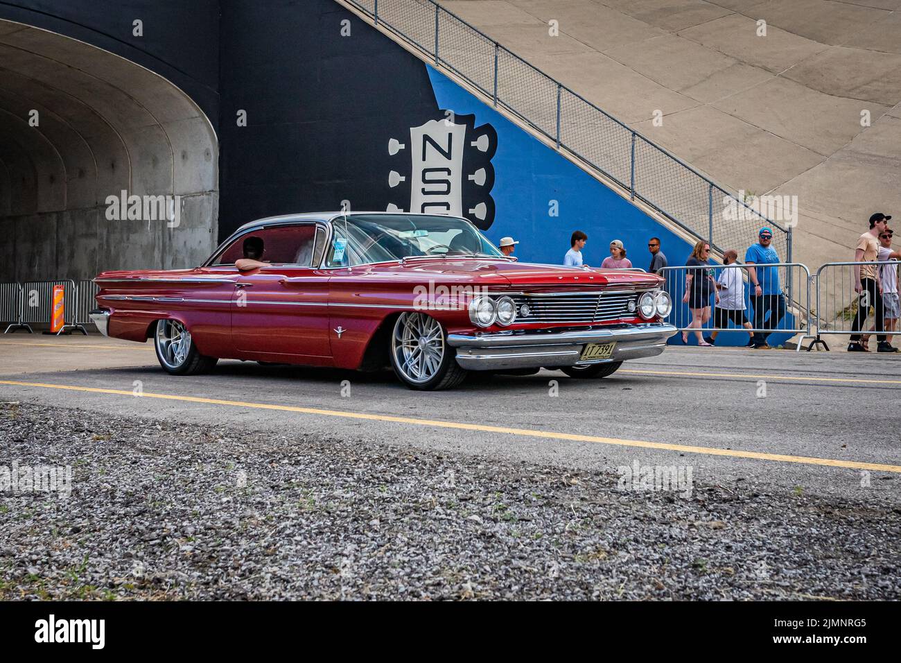 Lebanon, TN - May 14, 2022: Low perspective front view of a 1960 Pontiac Parisienne Hardtop Coupe driving on a road leaving a local car show. Stock Photo