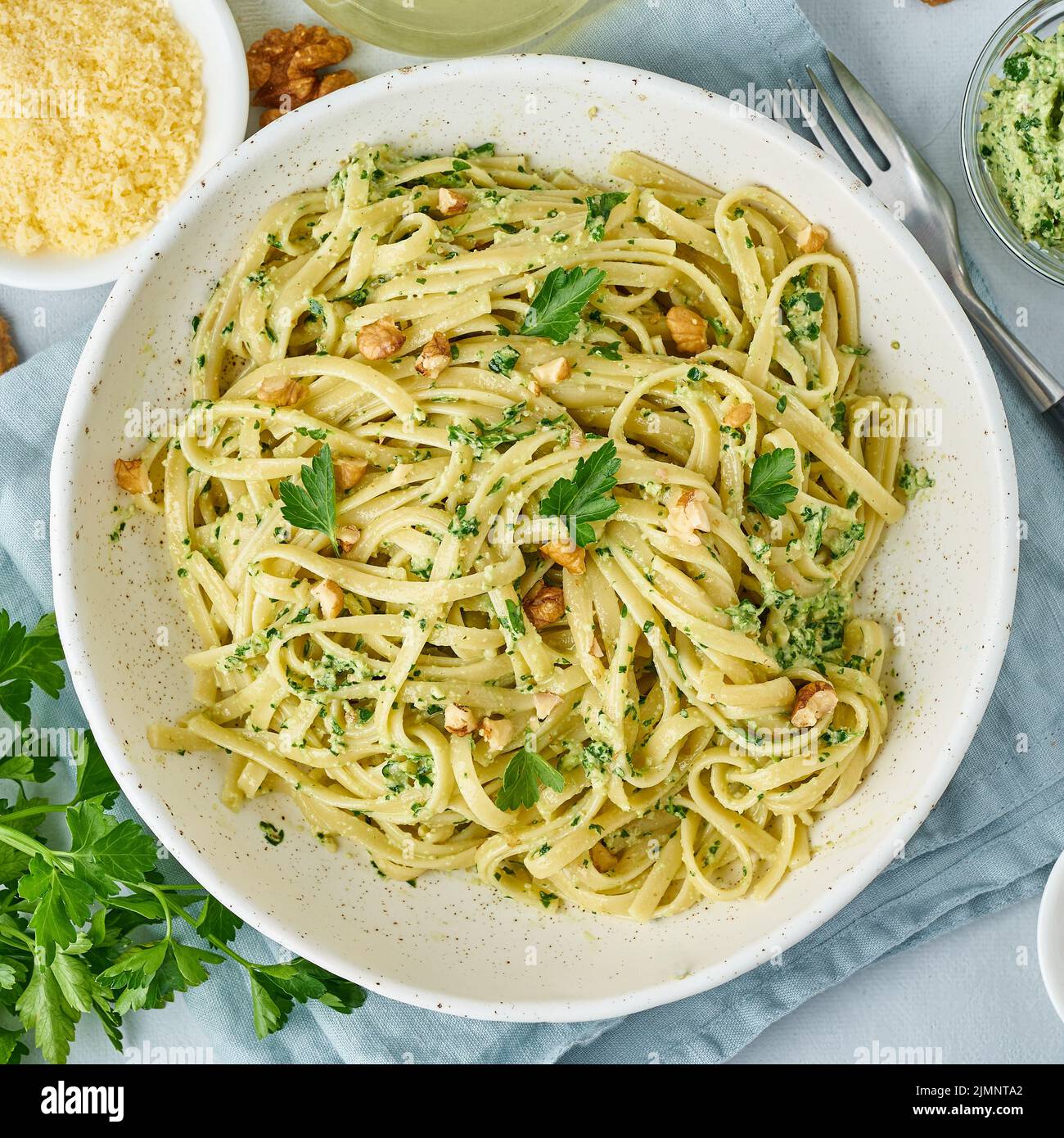 Pesto pasta, bavette with walnuts, parsley, garlic, nuts, olive oil. Top view Stock Photo