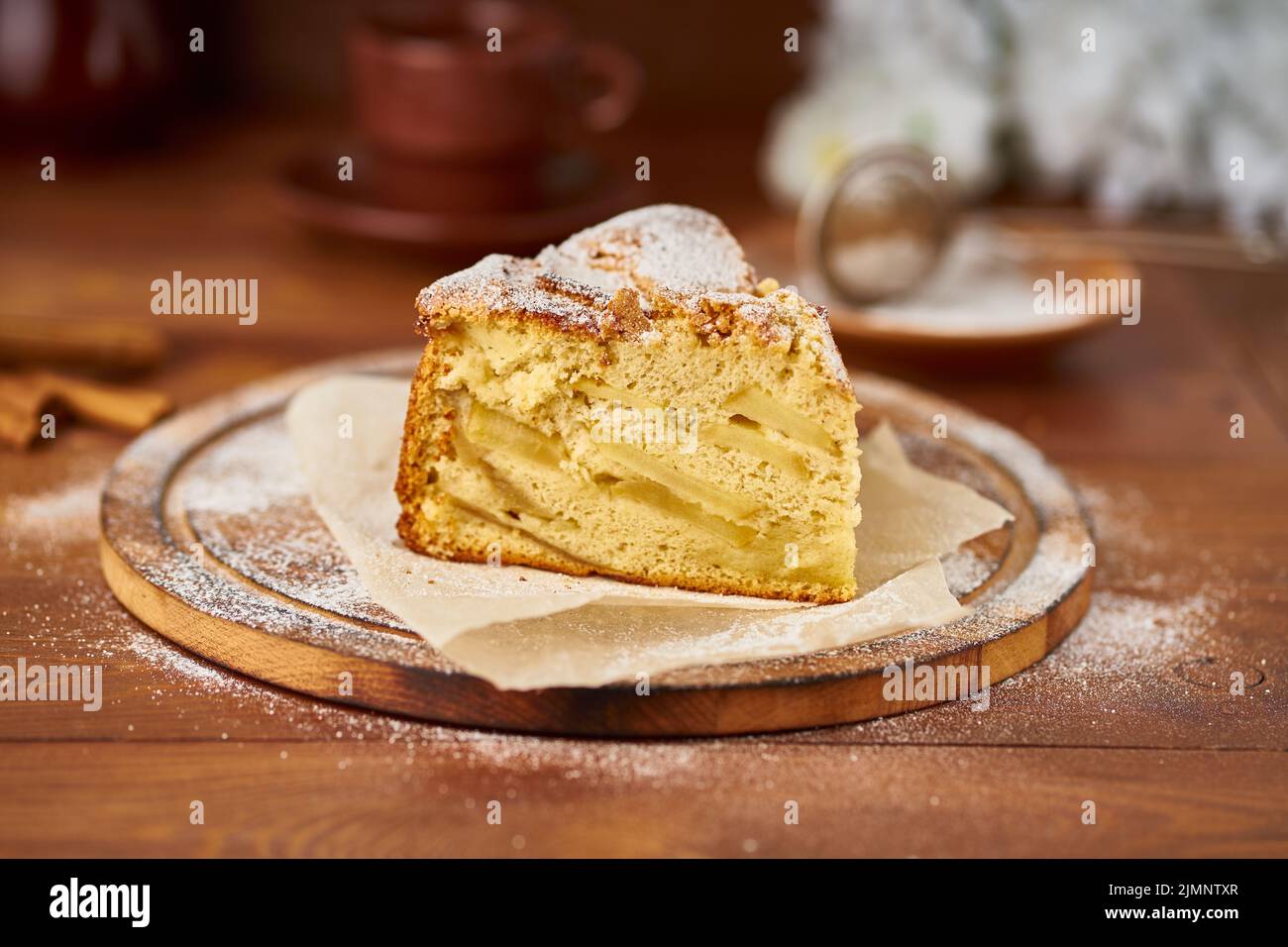 Piece of Apple french cake with apples, cinnamon on dark wooden kitchen table, side view Stock Photo