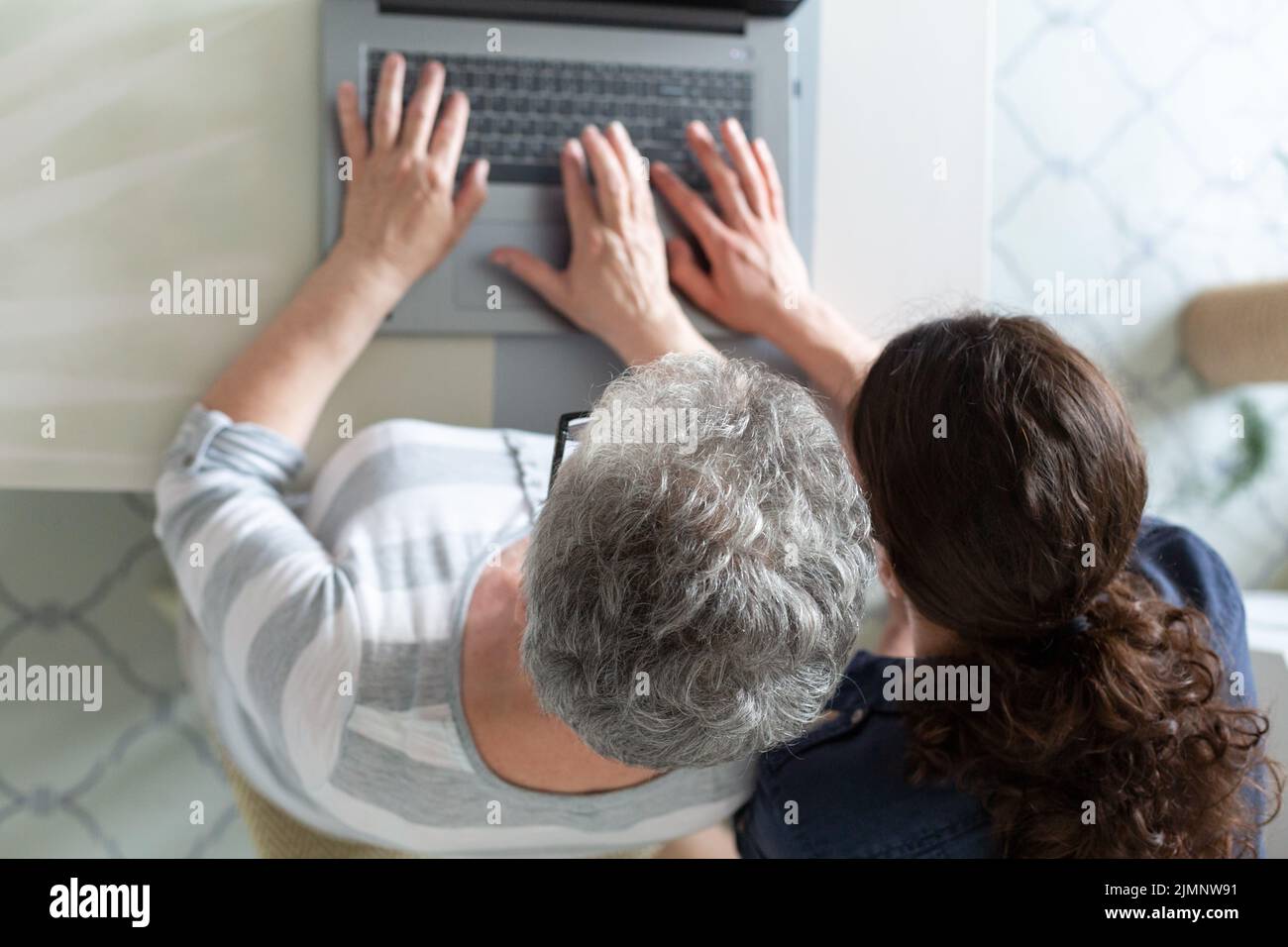 Young and senior women working on computer. Image taken from above Stock Photo