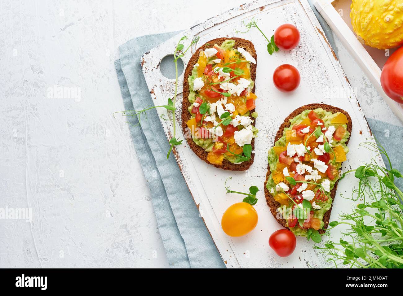 Avocado toast with feta and tomatoes, smorrebrod with ricotta, top view with copy space Stock Photo