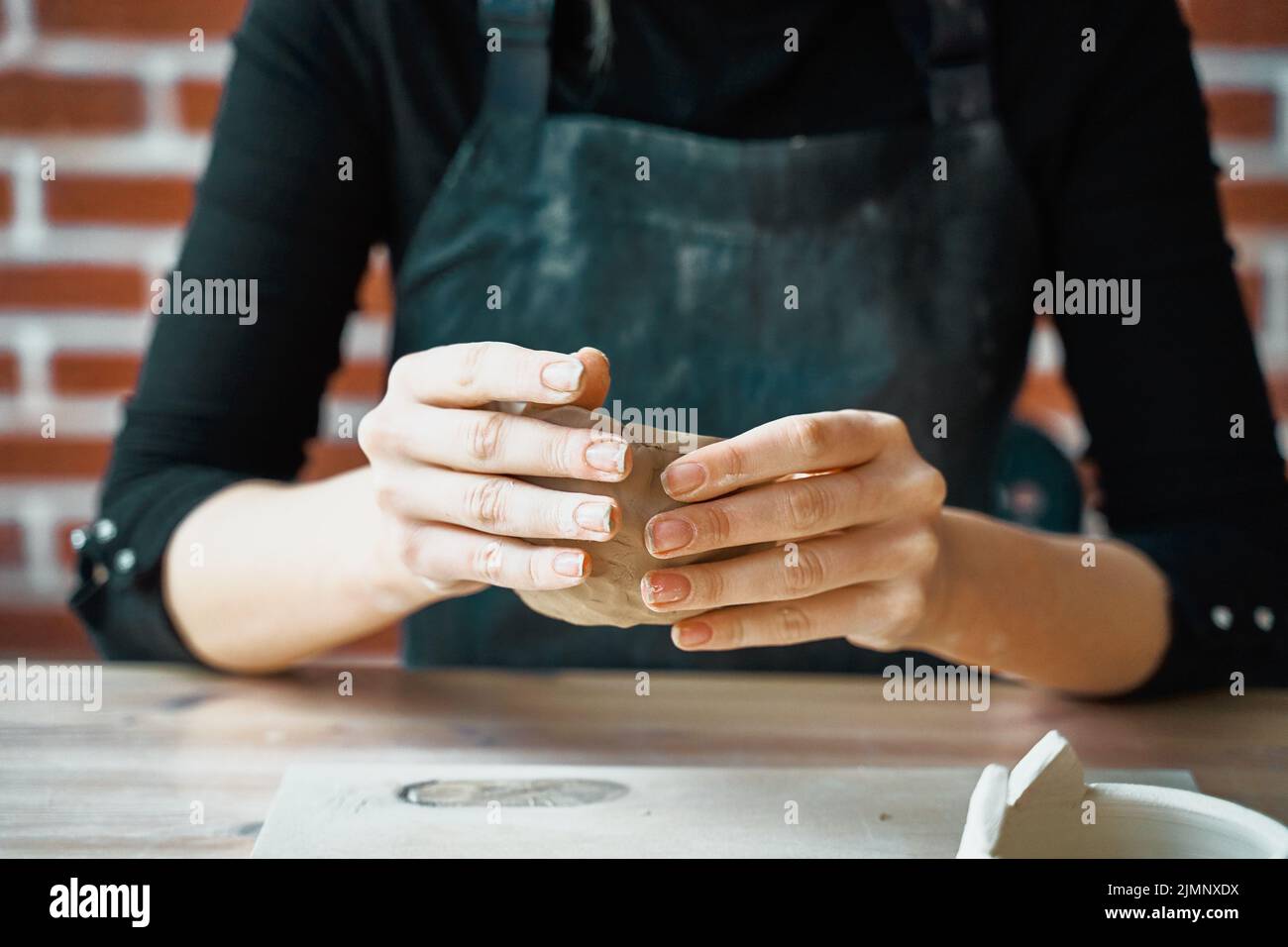 Woman making pottery, hands closeup, blurred background, focus on potters, palms with pottery. Concept for woman in freelance, b Stock Photo